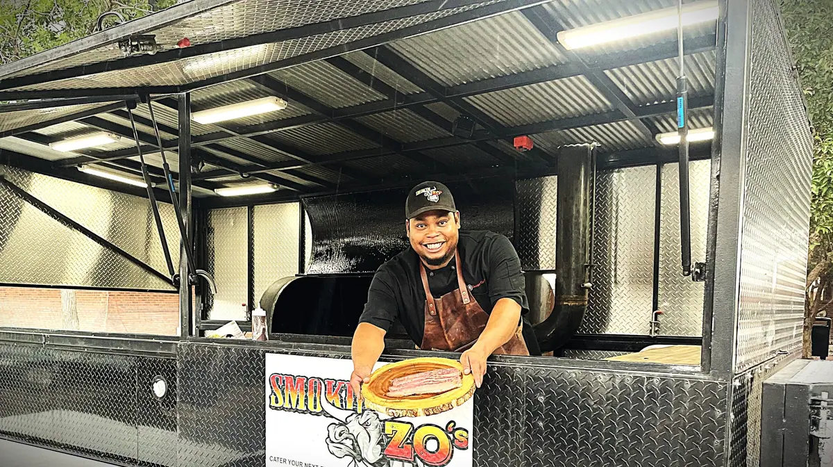 Smoked brisket and pulled pork plated with sides at a Smokin Zo's food truck event